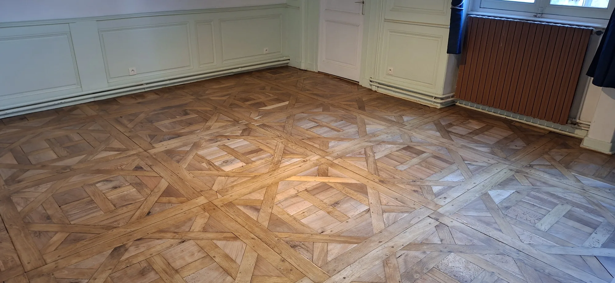 Grande pièce au parquet à compartiments poncé.
