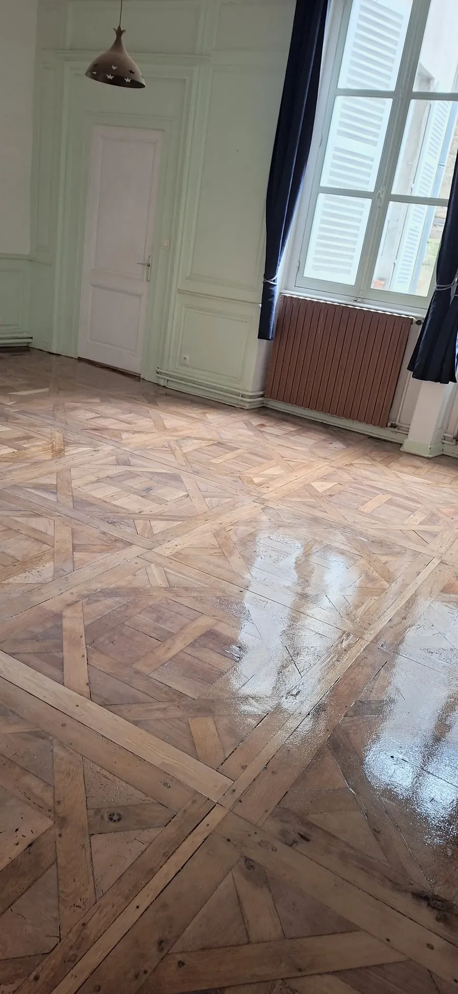 Parquet à compartiments vitrifié, avec les reflets des fenêtres.